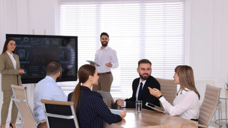 Interactive Flat Panel in an office conference room, with employees discussing.